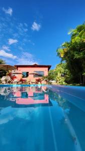 a swimming pool with a house in the background at Pousada Jardim do Éden in Serra do Cipo