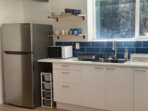 a kitchen with white cabinets and a refrigerator at Modern barn by the creek in Evergreen