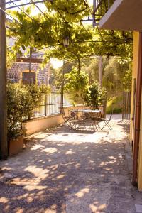 a patio with a table and chairs under a tree at CASA DEL PAVONE - Capometa in Marzano