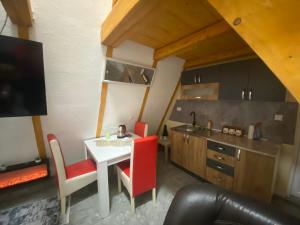 a kitchen with a white table and red chairs at ViP ROOMS PRENOCISTE 026 in Smederevo
