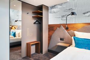 una camera da letto con un letto e un murale di nuvole di Motel One Zürich a Zurigo