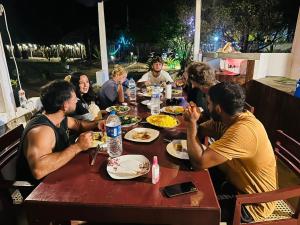 a group of people sitting around a table eating food at Ocean & Beach kite Hotel in Kalpitiya