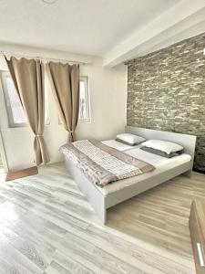 a bedroom with a bed and a brick wall at OneRoom in Ohrid