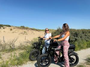 two women riding motorcycles on a dirt road at Van der Valk Palace Hotel Noordwijk in Noordwijk aan Zee