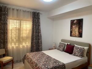 a bedroom with a bed and a window at Hendy's cozy apt in Praia