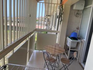 a balcony with a table and chairs and a window at Hendy's cozy apt in Praia +1 photo