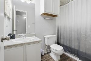 a white bathroom with a toilet and a sink at Comfortable 2BR2BA with Modern Touches in Jackson +16 photos