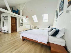 a bedroom with a large white bed and a wooden floor at Vakantiehuis Cédric in mesen