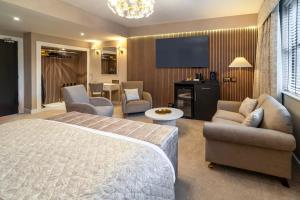 a hotel room with a bed and a flat screen tv at Daresbury Park Hotel in Daresbury