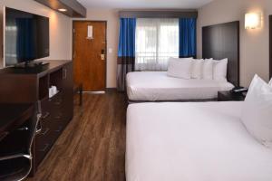 a hotel room with two beds and a television at Tarzana Inn in Tarzana
