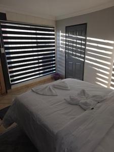 a white bed in a room with two large windows at The Good Samaritan 4 in eMalahleni +4 photos