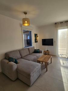 a living room with a couch and a table at Gîte Familial in Nabringhen