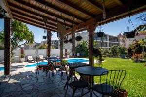 a patio with tables and chairs and a pool at Villa dos Corcéis in Esposende
