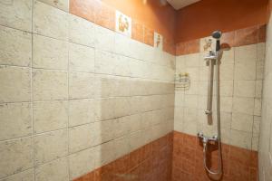 un bagno con box doccia e piastrelle arancioni di Villa Aemilius Hotel boutique Mérida a Mérida Altre 53 foto