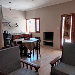 a kitchen and dining room with a table and chairs at Cabañas Tafi in Tafí del Valle