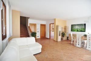 a living room with a white bed and a table at villa between lake and mountains in Valbrona