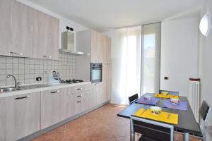 a kitchen with white cabinets and a table in it at villa between lake and mountains in Valbrona