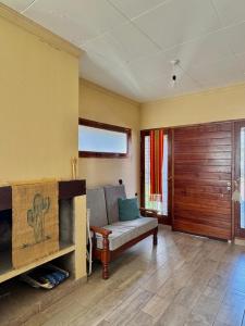 a living room with a couch and a wooden door at Cabañas Tafi in Tafí del Valle