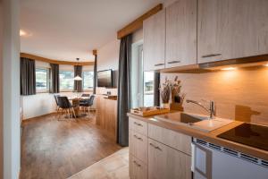 a kitchen with wooden cabinets and a dining room at Appartementhaus Fuchs in Itter
