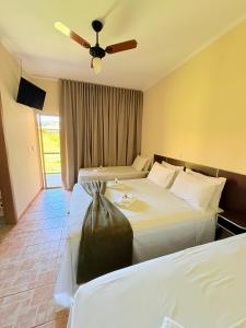 a hotel room with two beds and a ceiling fan at Montinni Hotel in Socorro +49 photos