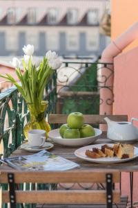 stół z talerzami jedzenia i wazonem kwiatów w obiekcie Lisbon Apartment Bairro Alto - Bica 3 w Lizbonie