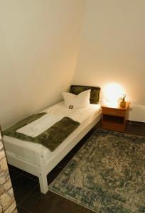 ein Schlafzimmer mit einem weißen Bett und einem Nachttisch in der Unterkunft Fünf A in Fürth