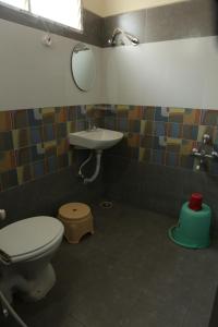 a bathroom with a toilet and a sink and a mirror at SV Grand in Proddatūr +18 photos