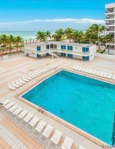 an overhead view of a swimming pool with a building and the ocean at Castle B6 in Miami Beach