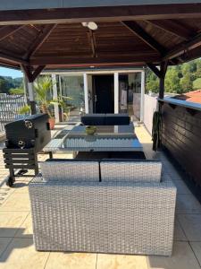 een terras met rieten zitmeubelen onder een pergola bij Luxus-Loft Atrium -X- in Rorbas