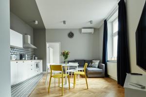 cocina y comedor con mesa y sillas en PlayRoom Aparthotel en Cracovia