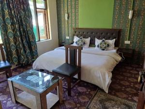 a hotel room with a bed and a table at Dreamland Cottage in Pahalgām
