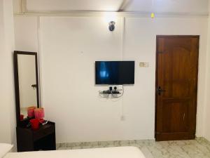 a room with a television on a wall with a door at Fair Heaven Villa in Chilaw +20 photos
