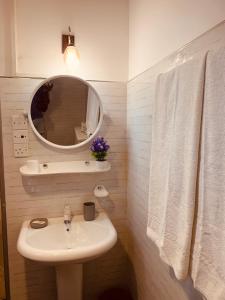 a white bathroom with a sink and a mirror at Fair Heaven Villa in Chilaw
