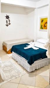 una camera da letto con un letto con una coperta blu di CASA COMPLETA 5min DA PRAIA JUQUEHY a São Sebastião
