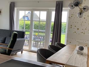 a living room with a table and chairs and a window at Reetdachhaus Windblume - super gemütlich in Zinnowitz