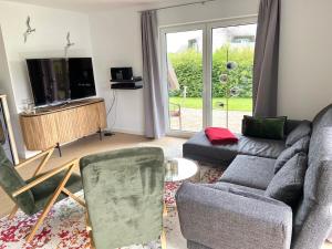 a living room with a couch and a tv at Reetdachhaus Windblume - super gemütlich in Zinnowitz