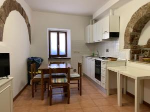 eine Küche mit weißen Schränken und einem Tisch und Stühlen in der Unterkunft Monte Cavallo in Assisi