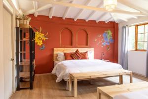 a bedroom with a bed and a red wall at Tariq Sacred Valley in Urubamba
