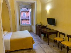 ein Schlafzimmer mit Bett, Schreibtisch und Fernseher in der Unterkunft Monte Cavallo in Assisi