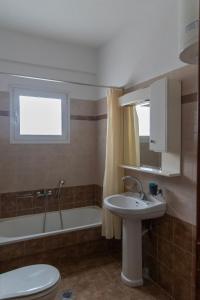 a bathroom with a sink and a tub and a toilet at Philoxenia Studio Larissa in Larisa +10 photos