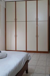 a bedroom with white cabinets and a bed at Philoxenia Studio Larissa in Larisa