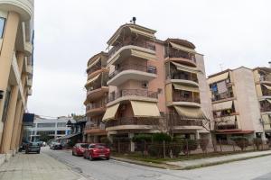 a tall building with cars parked in front of it at Philoxenia Studio Larissa in Larisa