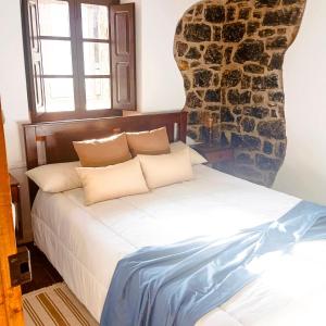 una camera da letto con un letto e un muro di pietra di Casa Rural Ribota! a Ribota