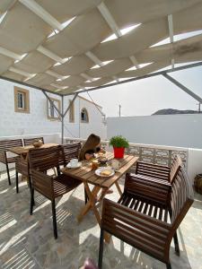 a woman sitting at a table on a patio at Calliope #1 in Skala