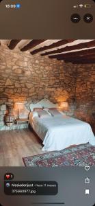 a bedroom with a bed and a stone wall at Masiadenjust in Rojals