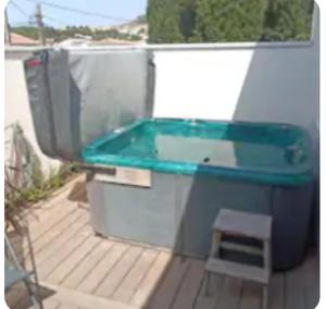 a bath tub sitting on top of a deck at O'sun avec jacuzzi privatif in Frontignan