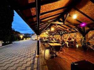 a restaurant with tables and people sitting at tables at Transylvanian Nest in Cristian