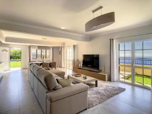 a large living room with a couch and a tv at Villa Baradaye by Atlantic Holiday in Estreito da Calheta