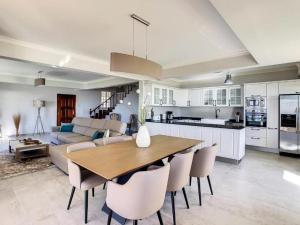 a kitchen and living room with a wooden table and chairs at Villa Baradaye by Atlantic Holiday in Estreito da Calheta