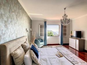 a living room with a couch and a chandelier at Villa Baradaye by Atlantic Holiday in Estreito da Calheta +28 photos